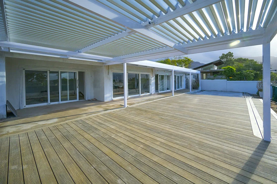 White aluminium louvre roof over a timber deck