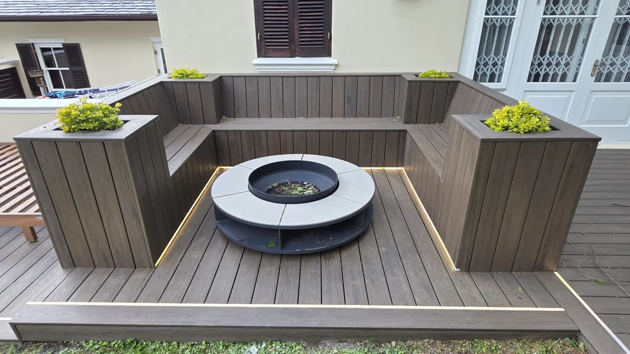Built-in timber-look seating and planters around a fire pit