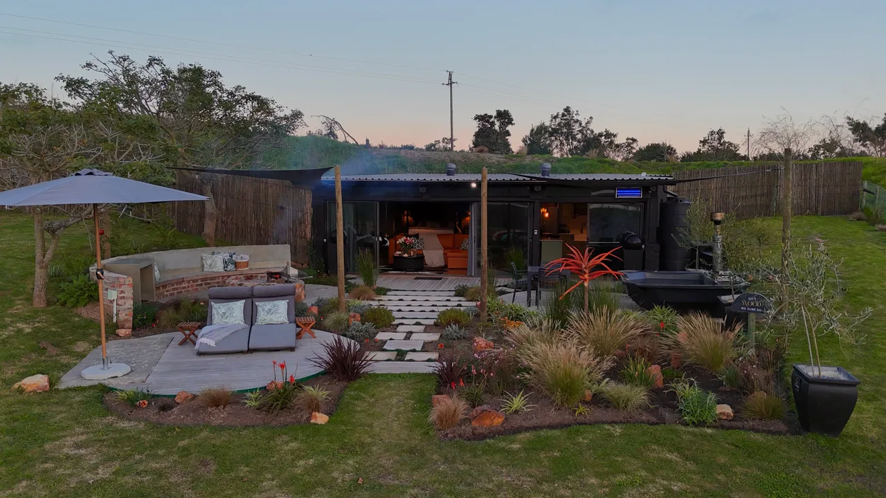 Garden suite — Garden suite at dusk with a lounge deck and planted garden in front
