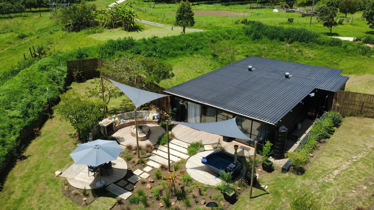 Garden suite — Wide aerial of the garden suite roof, decks and landscaped garden