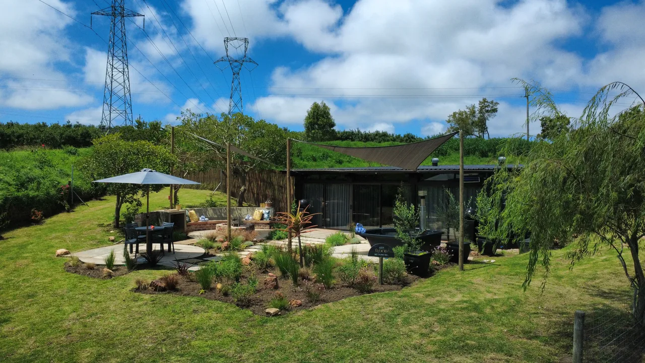 Garden suite — Garden suite with deck seating and landscaped beds under a blue sky