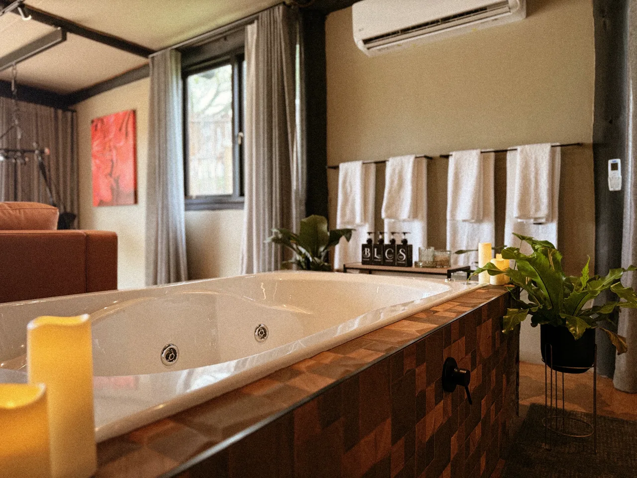 Garden suite — Suite bathroom with a built-in spa bath, towels and candles