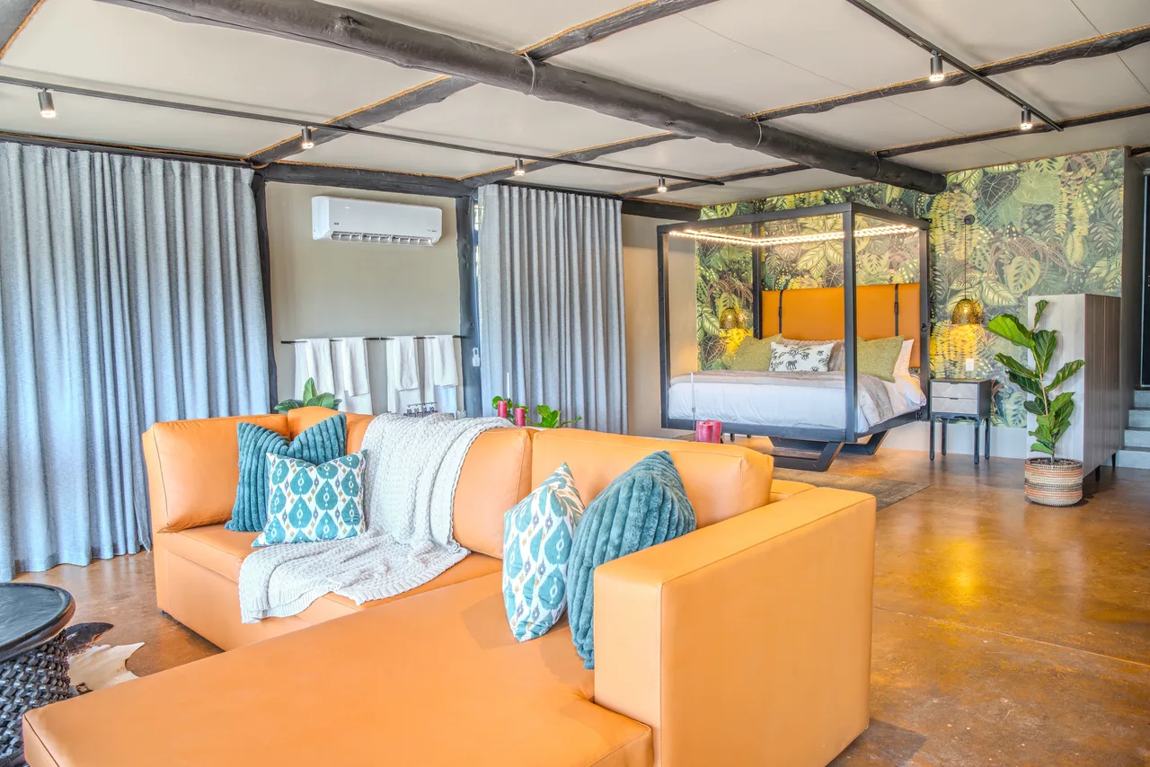Garden suite — Suite lounge with orange sofas and the bedroom beyond