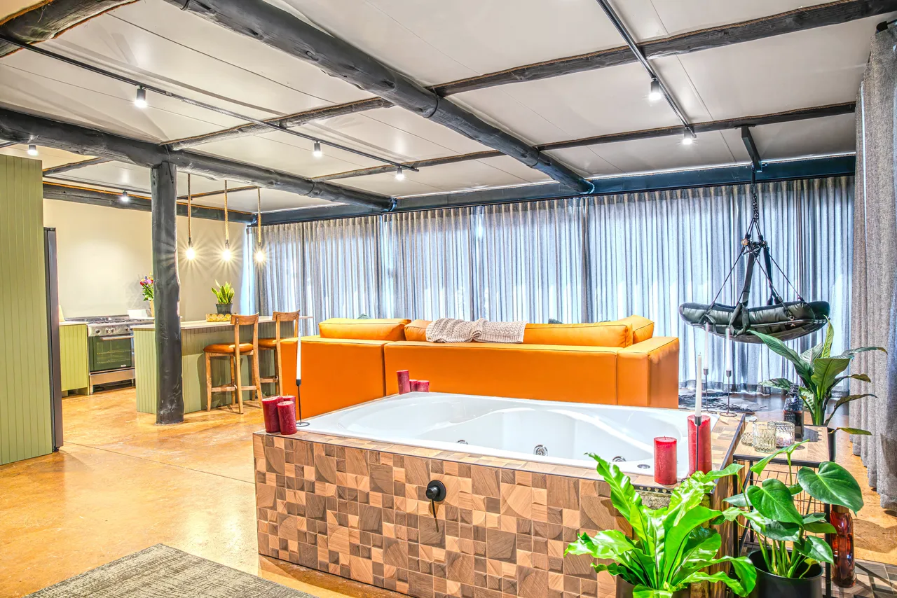 Garden suite — Spa bath and lounge with orange sofas inside the suite