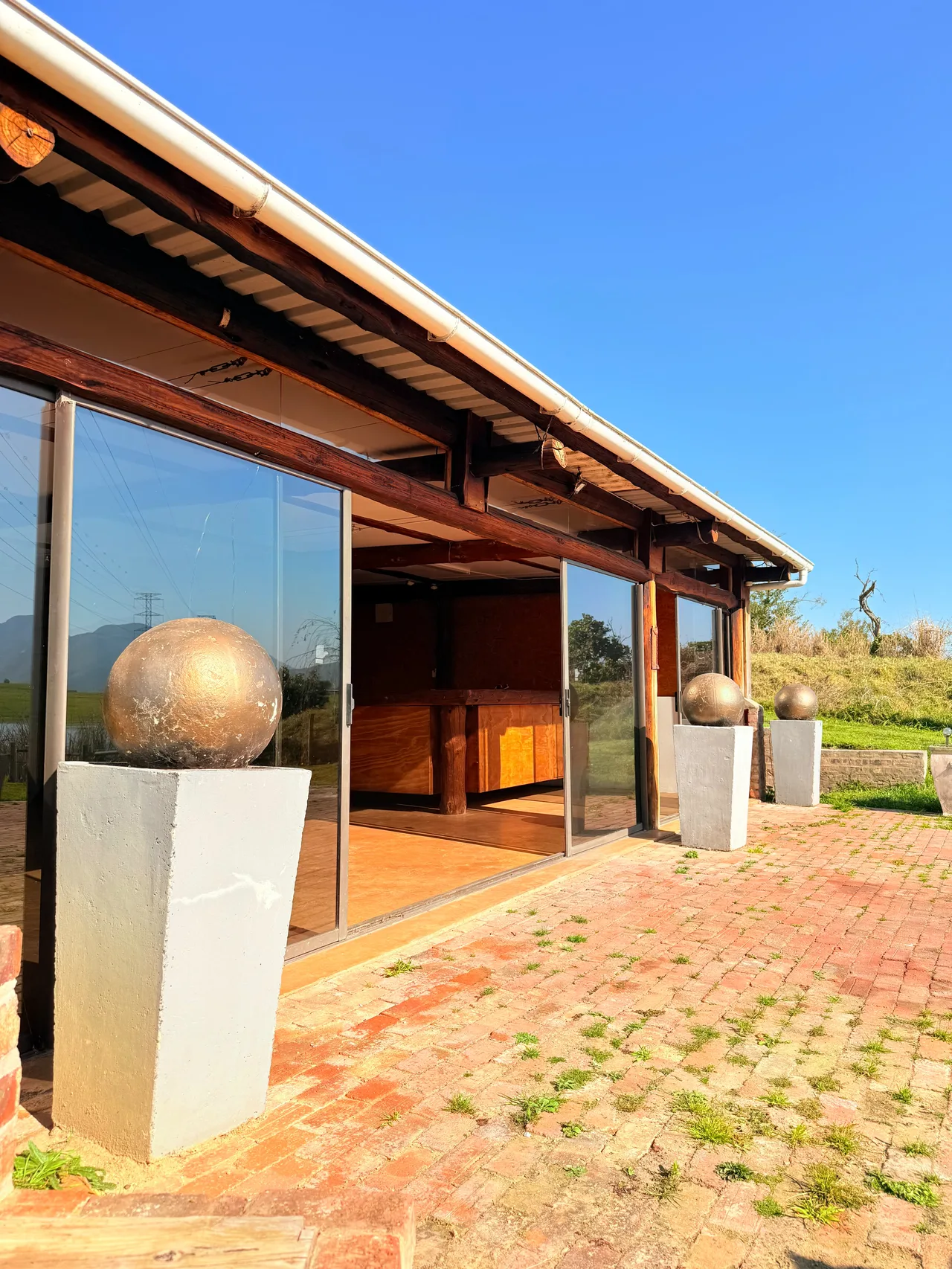 Garden suite — Side terrace of the garden suite with glass doors and brick paving