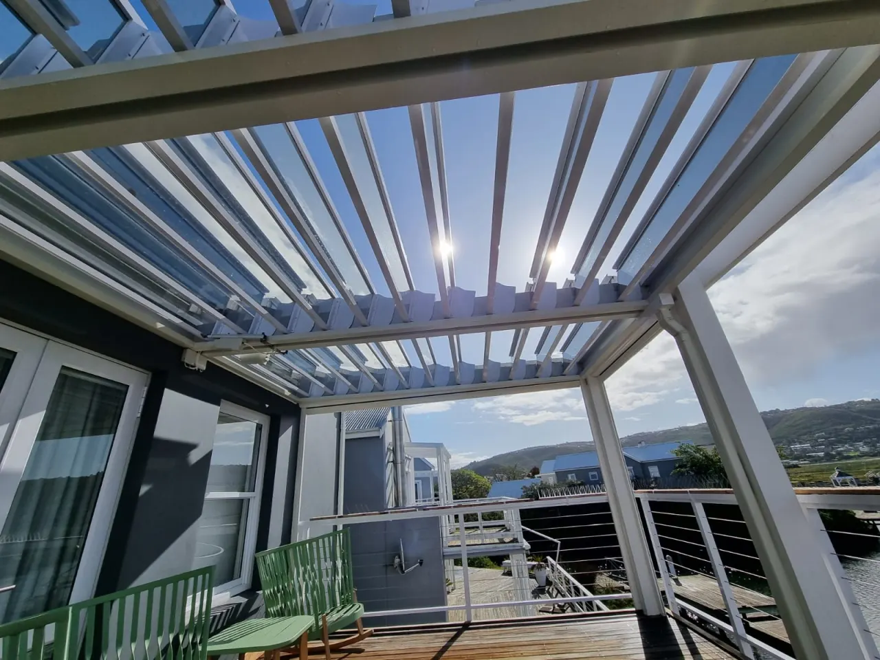 Glass louvre awning over a timber deck with mountain views