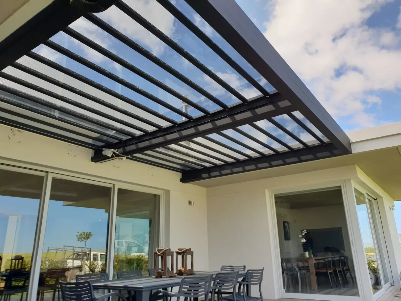 Charcoal-framed glass louvre roof over an outdoor dining patio