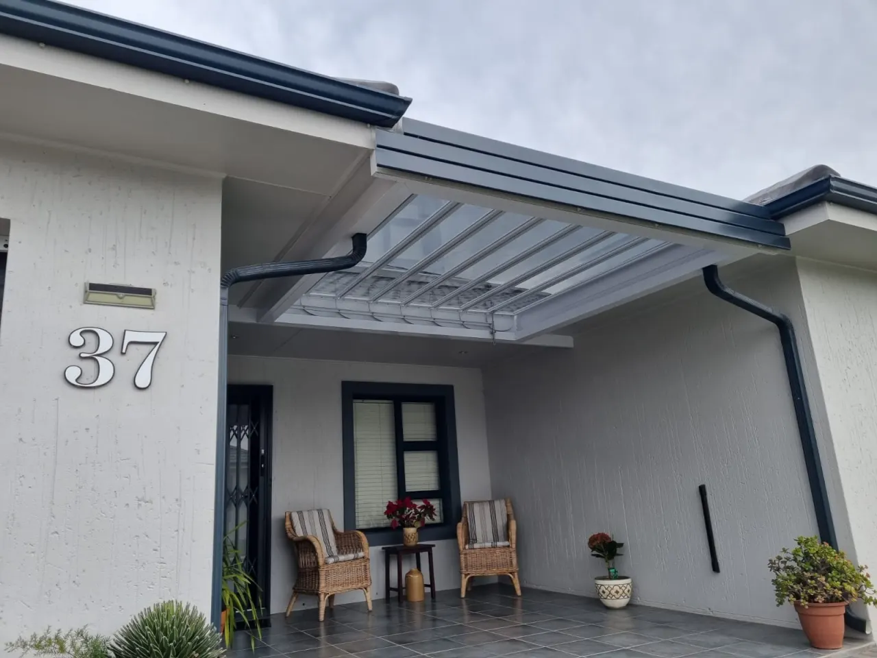 Glass louvre awning sheltering a front entrance