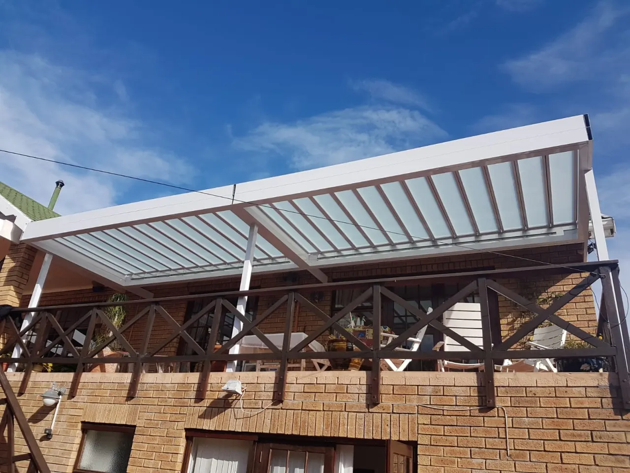 White louvre awning over a raised timber terrace