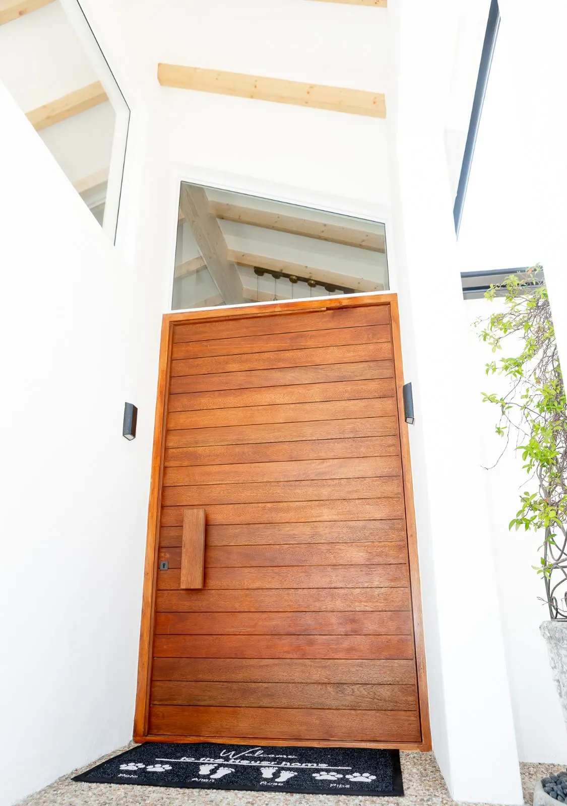 Timber pivot front door in a double-volume entrance