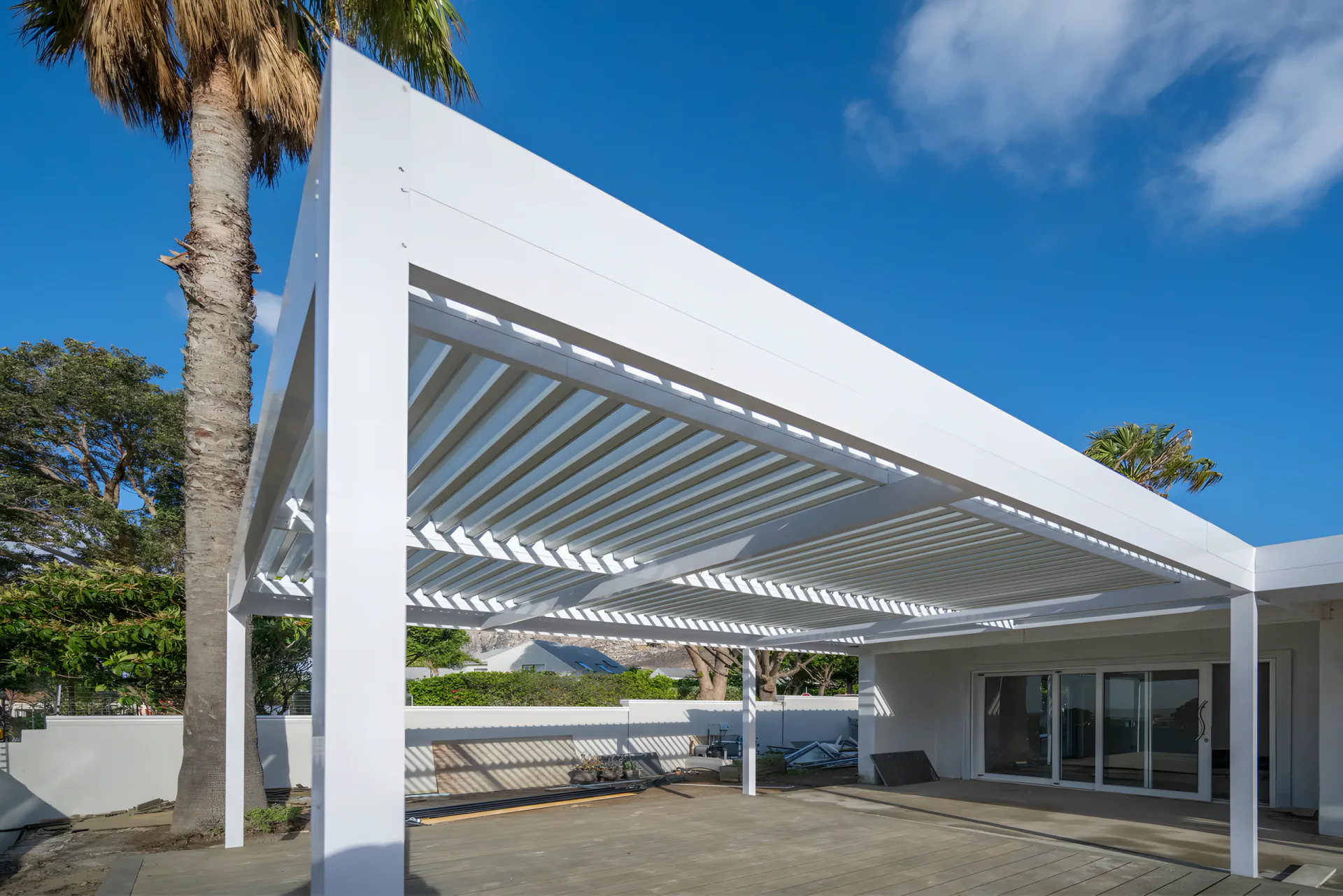 White aluminium louvre awning against a clear blue sky