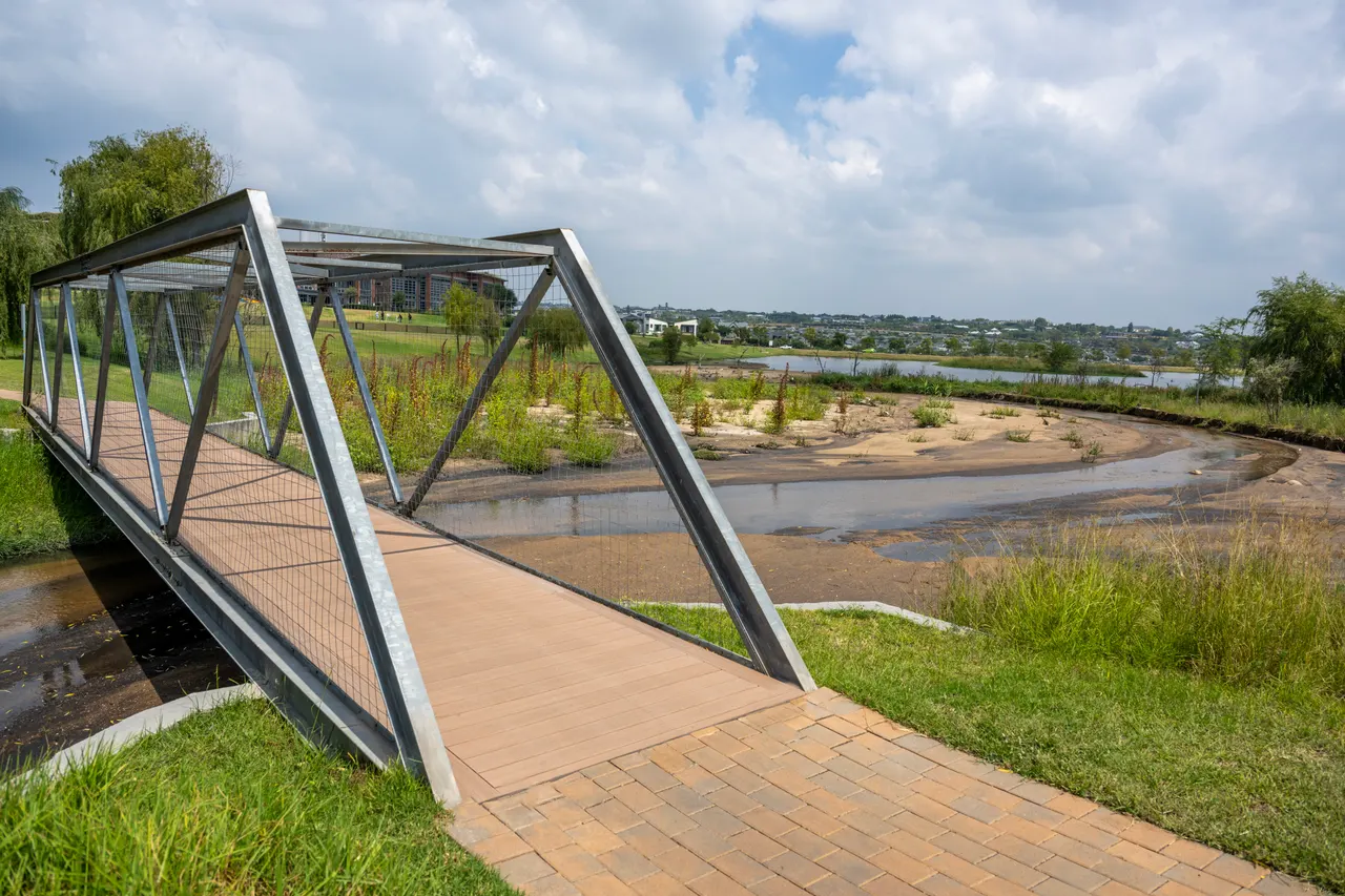 Steel truss pedestrian bridge with a timber deck over a river