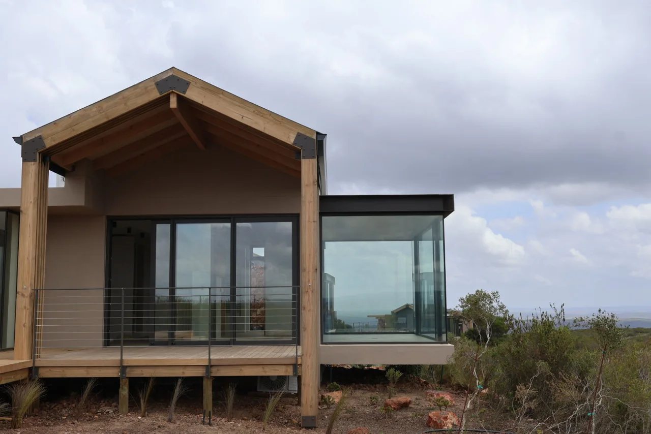 Gabled lodge suite raised on timber posts above the fynbos