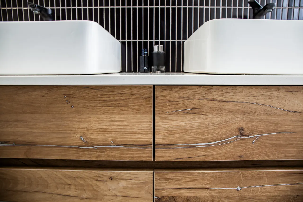 Book-matched timber drawer fronts beneath a white worktop