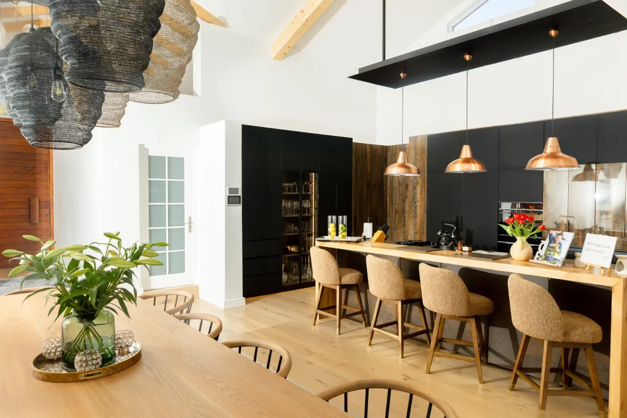 Kitchen island with copper pendants beside the dining table in the Westlake house