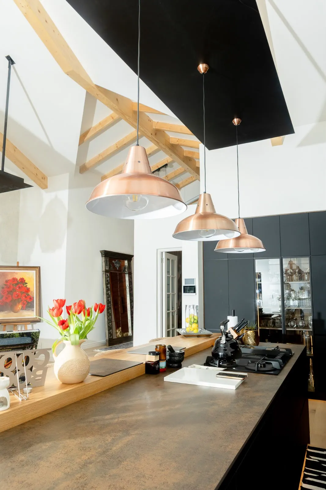 Copper pendants over a timber-topped kitchen island in the Westlake house